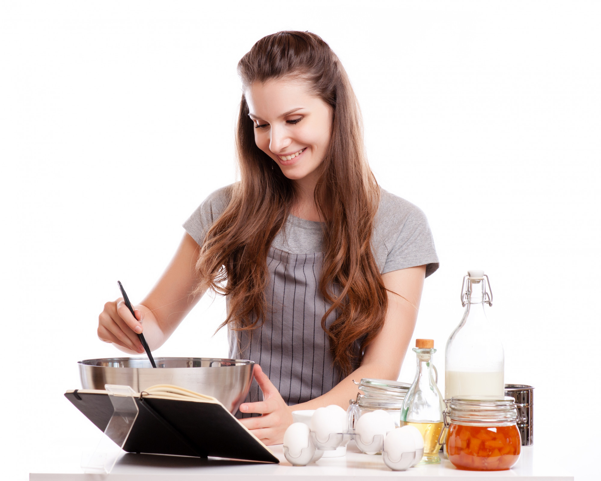 Student cooking at home with instructor on screen